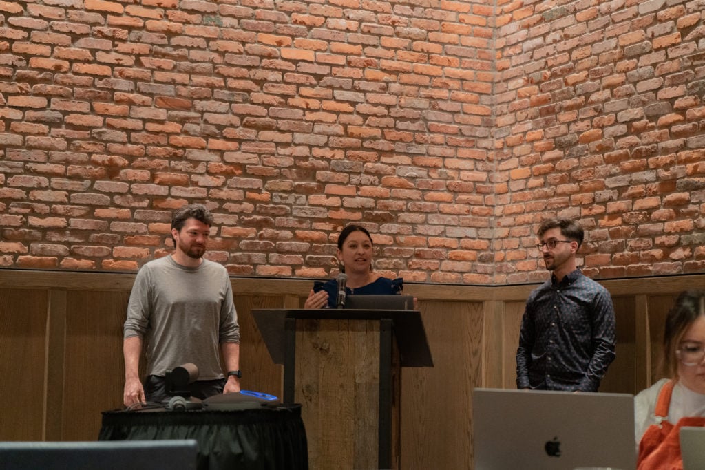 three people standing in front of a podium. 