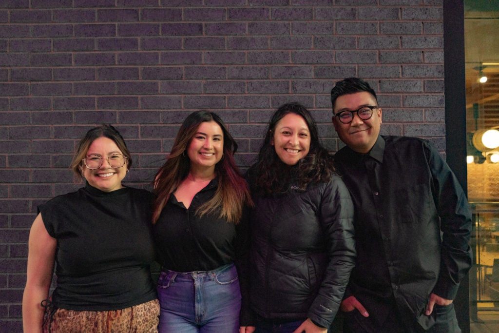 four individuals smiling for a photo