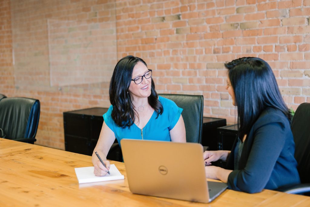 Two-women-talking-to-each-other-in-an-office