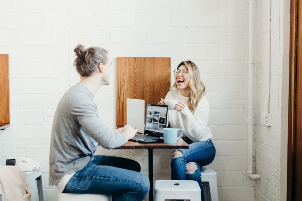 Two college students working on a project together over coffee