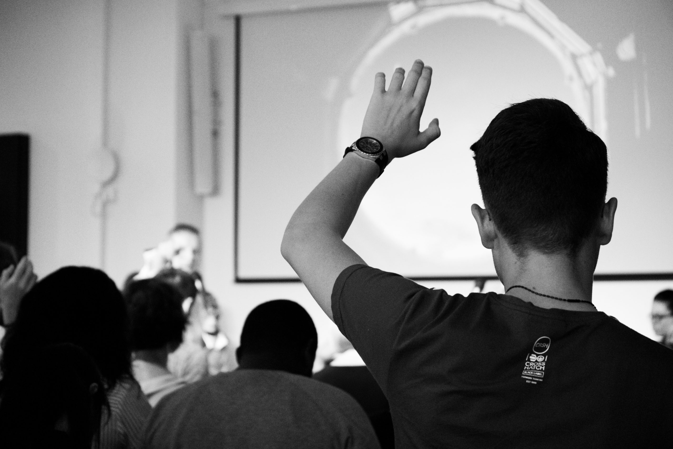 A student raising their hand and engaging in class.